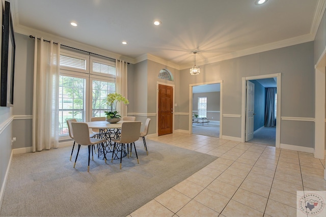 dining area with light tile patterned floors, ornamental molding, and a chandelier