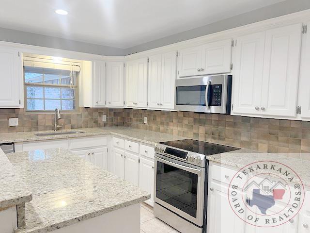 kitchen featuring white cabinets, appliances with stainless steel finishes, and sink