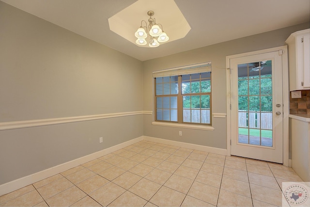 interior space with a notable chandelier, a wealth of natural light, and light tile patterned flooring