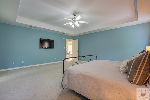 bedroom featuring ceiling fan, carpet floors, and a tray ceiling