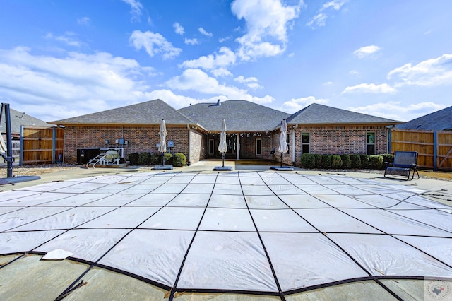 back of house featuring a covered pool and a patio