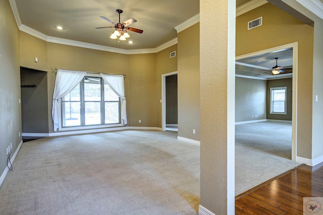 carpeted empty room featuring plenty of natural light, baseboards, and ornamental molding