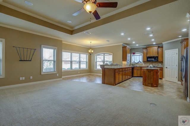 kitchen with hanging light fixtures, light carpet, backsplash, and kitchen peninsula