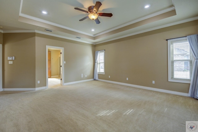 unfurnished room featuring a tray ceiling, visible vents, light carpet, and baseboards