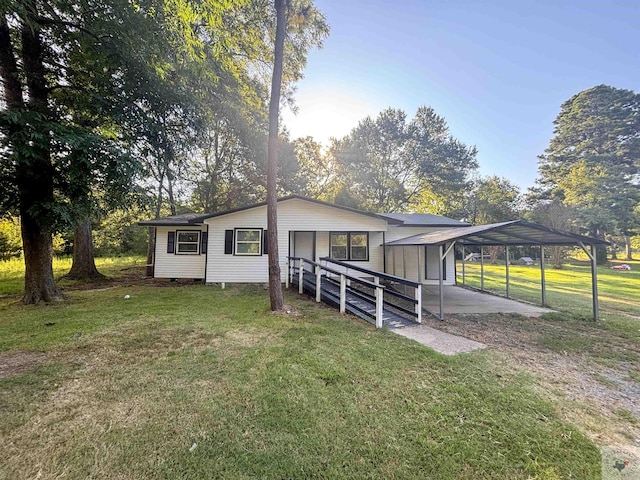 exterior space with a carport and a front lawn