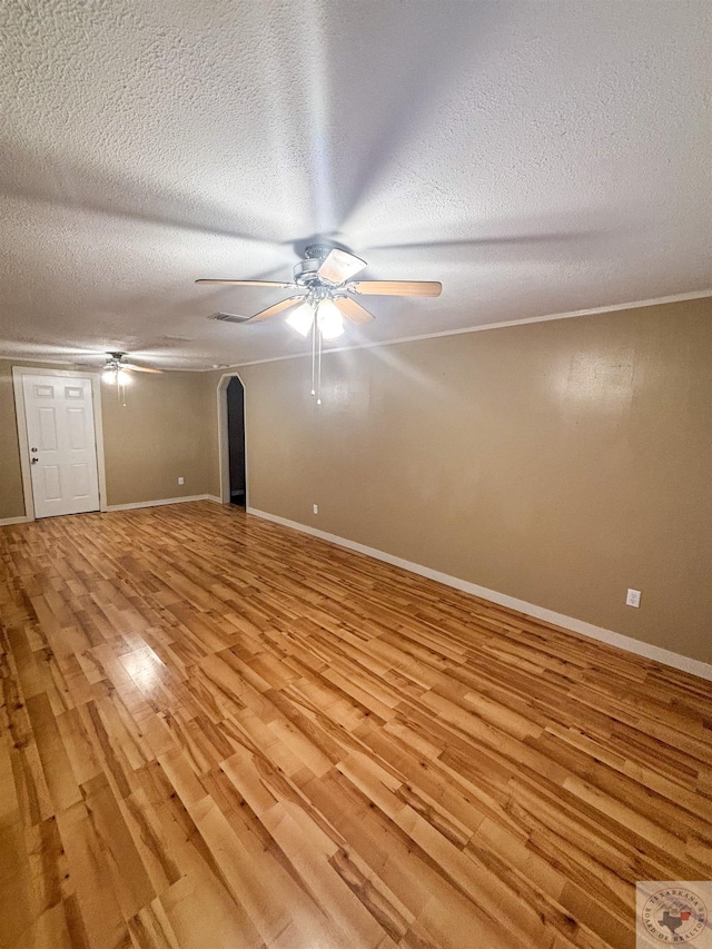 empty room with ceiling fan, a textured ceiling, and light hardwood / wood-style flooring