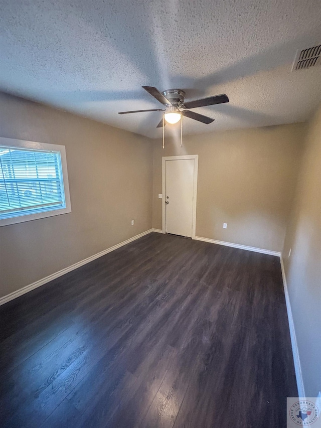 spare room featuring a textured ceiling, ceiling fan, and dark hardwood / wood-style flooring