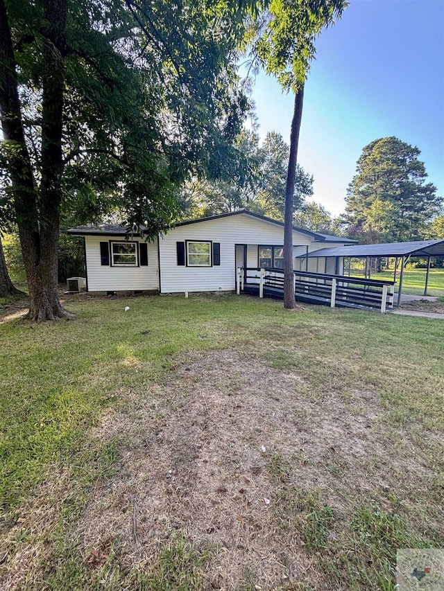 view of front of property with a front lawn and central AC