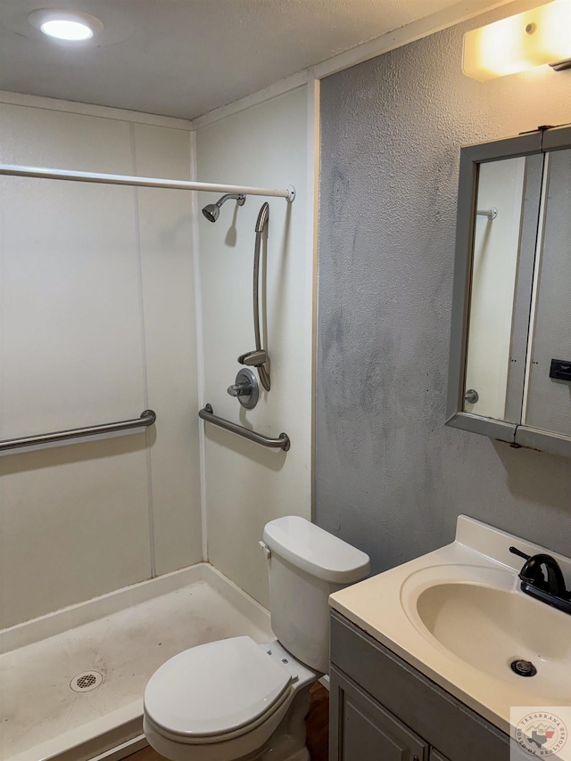 bathroom featuring a shower, toilet, and vanity