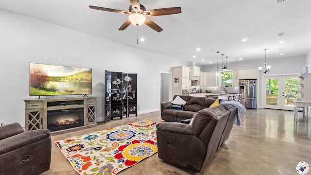 living room with concrete floors, visible vents, ceiling fan, recessed lighting, and a glass covered fireplace