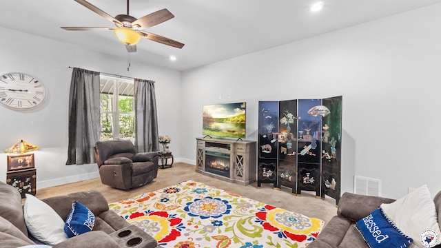 living area featuring ceiling fan, a warm lit fireplace, visible vents, recessed lighting, and baseboards