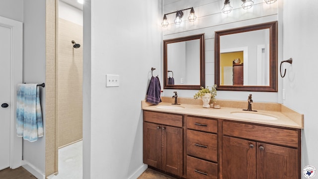 bathroom featuring a walk in shower, double vanity, and a sink