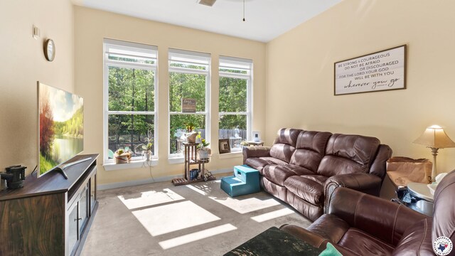 living room featuring baseboards, a ceiling fan, and carpet