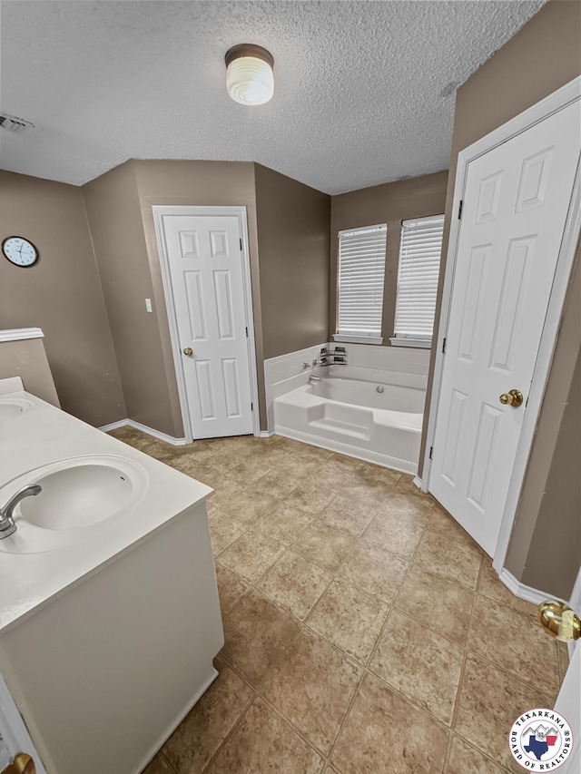 307 Kimball Cir, Wake Village, TX 75501 - full bathroom with a garden tub, a textured ceiling, double vanity, and baseboards