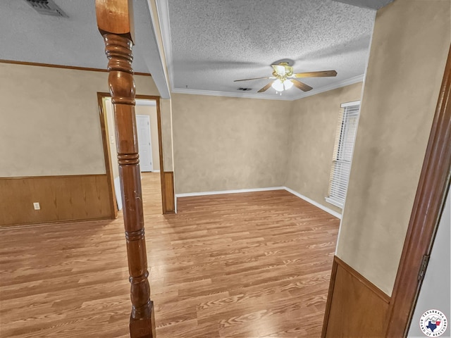 307 Kimball Cir, Wake Village, TX 75501 - empty room featuring ceiling fan, light wood finished floors, a textured ceiling, ornamental molding, and wainscoting