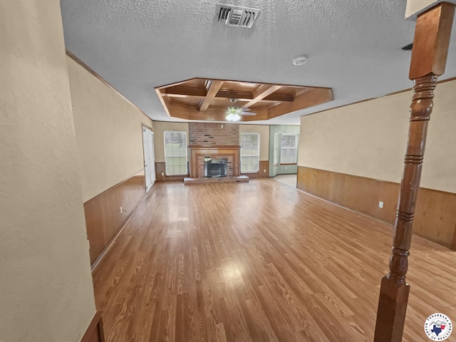 307 Kimball Cir, Wake Village, TX 75501 - unfurnished living room with coffered ceiling, ceiling fan, wood finished floors, a brick fireplace, and crown molding
