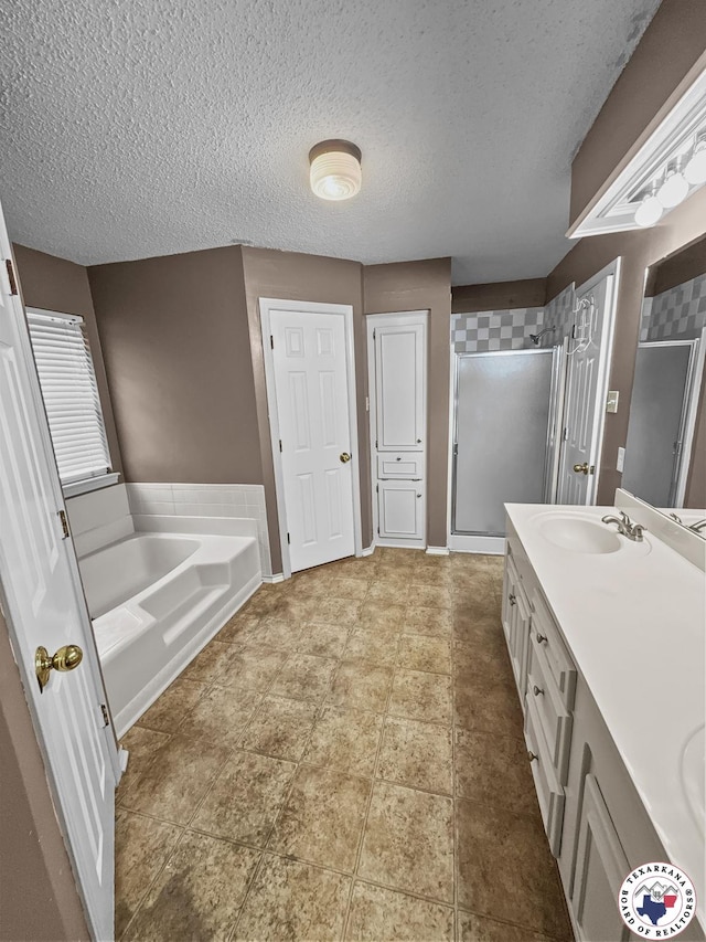 307 Kimball Cir, Wake Village, TX 75501 - bathroom featuring a shower stall, double vanity, a garden tub, and a textured ceiling