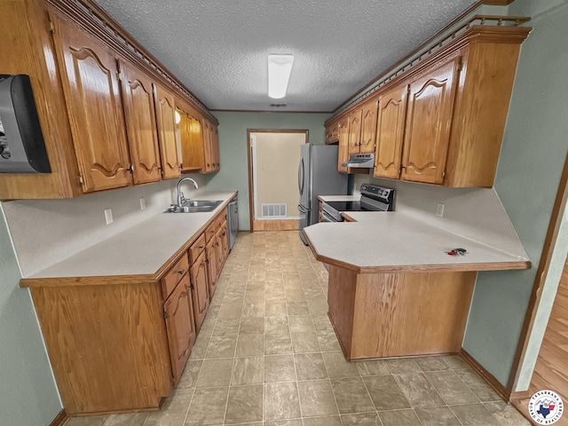 307 Kimball Cir, Wake Village, TX 75501 - kitchen with a sink, appliances with stainless steel finishes, light countertops, a peninsula, and a textured ceiling