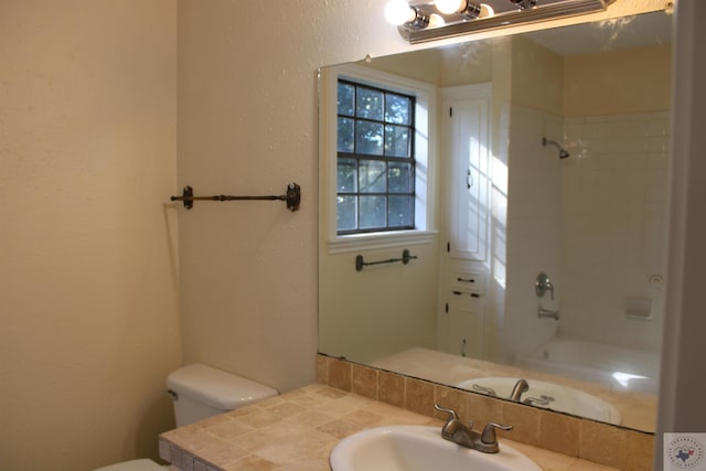 full bathroom featuring toilet, vanity, and tiled shower / bath