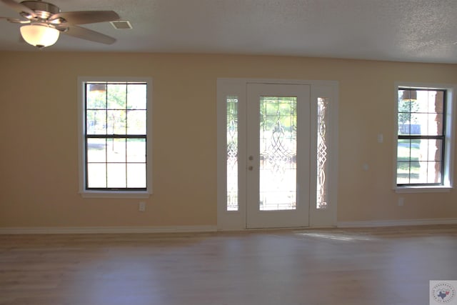 foyer with ceiling fan, hardwood / wood-style floors, and a textured ceiling