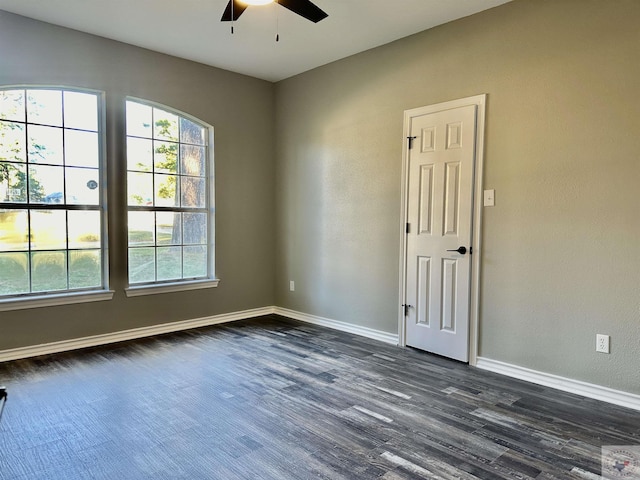 empty room featuring ceiling fan, dark hardwood / wood-style flooring, and a healthy amount of sunlight