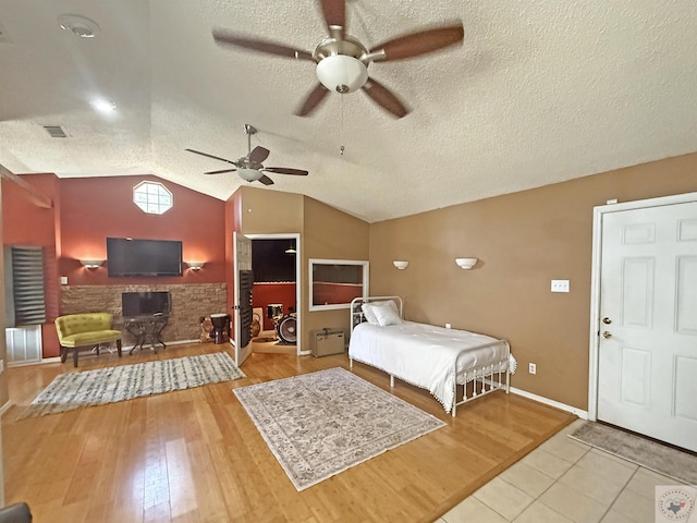 bedroom featuring visible vents, lofted ceiling, a textured ceiling, and wood finished floors