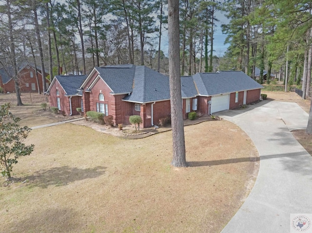 view of front of home featuring a garage, brick siding, roof with shingles, and driveway