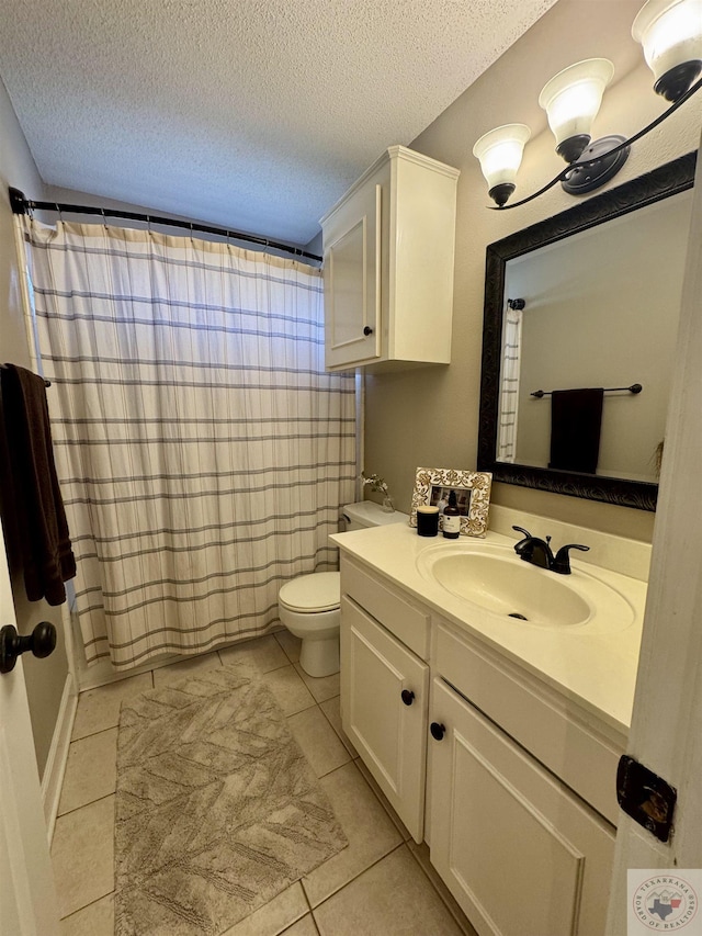 bathroom with a textured ceiling, toilet, vanity, and tile patterned flooring