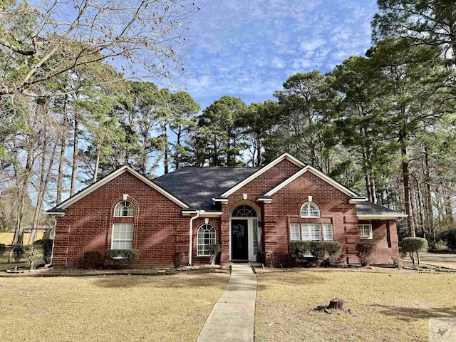 ranch-style home featuring brick siding and a front yard