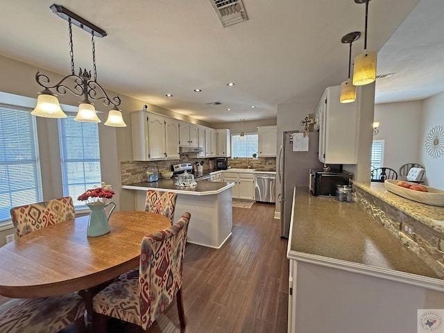 dining area with recessed lighting, visible vents, plenty of natural light, and dark wood-style floors