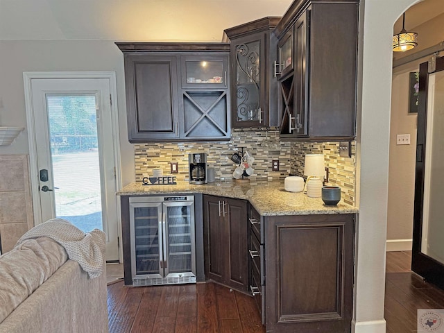 bar featuring tasteful backsplash, dark wood-type flooring, baseboards, beverage cooler, and a dry bar