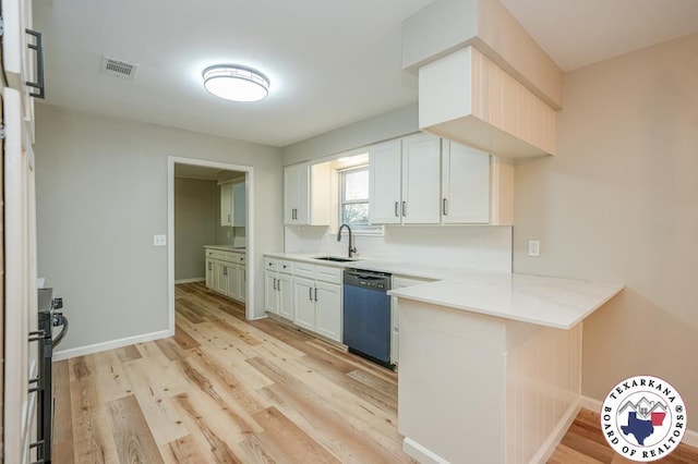 kitchen with a sink, light wood-style flooring, a peninsula, visible vents, and dishwashing machine