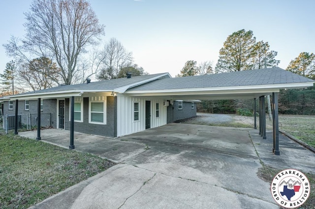 view of front of property with an attached carport, brick siding, and aphalt driveway