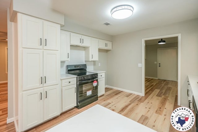 kitchen with white cabinets, visible vents, black electric range, and light wood-style flooring