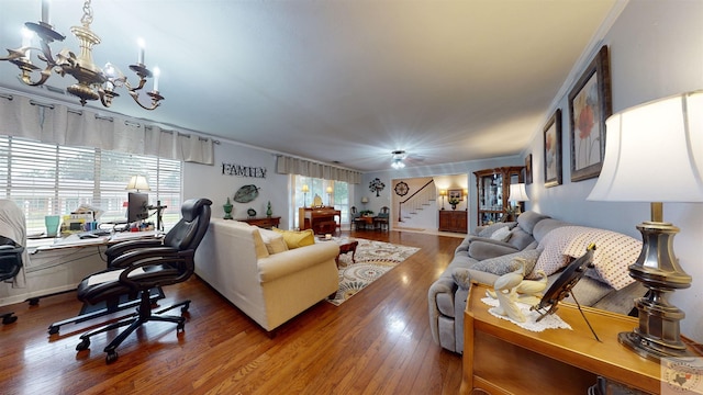 living room featuring an inviting chandelier, crown molding, and hardwood / wood-style floors