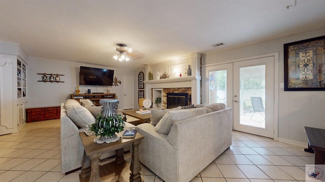 living room with french doors, a fireplace, and light tile patterned floors