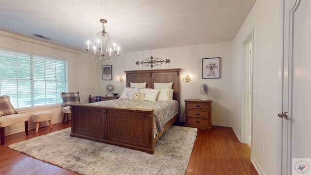 bedroom featuring an inviting chandelier and dark hardwood / wood-style floors