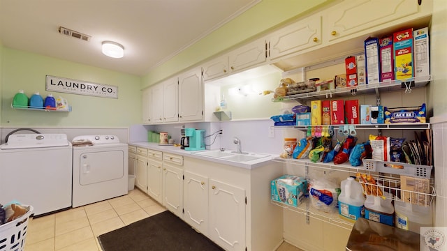 washroom featuring washer and dryer, light tile patterned flooring, sink, and cabinets