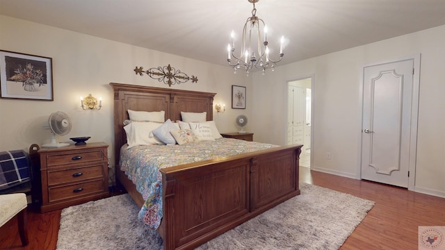 bedroom featuring wood-type flooring and an inviting chandelier