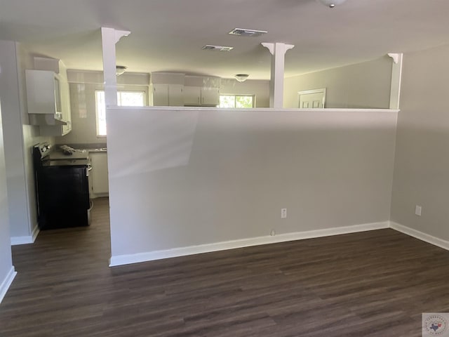 empty room with dark wood-type flooring and a healthy amount of sunlight