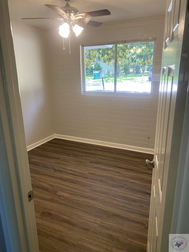 empty room featuring ceiling fan and dark wood-type flooring