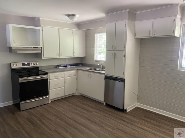 kitchen featuring appliances with stainless steel finishes, white cabinetry, brick wall, sink, and dark hardwood / wood-style flooring