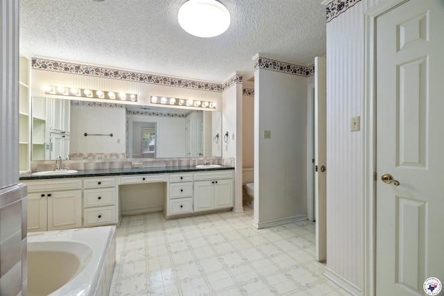 803 Lakeridge Pl, Texarkana, TX 75503 - bathroom featuring tile patterned floors, a textured ceiling, double vanity, toilet, and a bath
