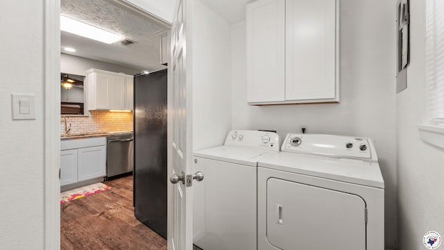 8809 N Kings Hwy, Texarkana, TX 75503 - washroom with washing machine and clothes dryer, dark wood-type flooring, and cabinet space