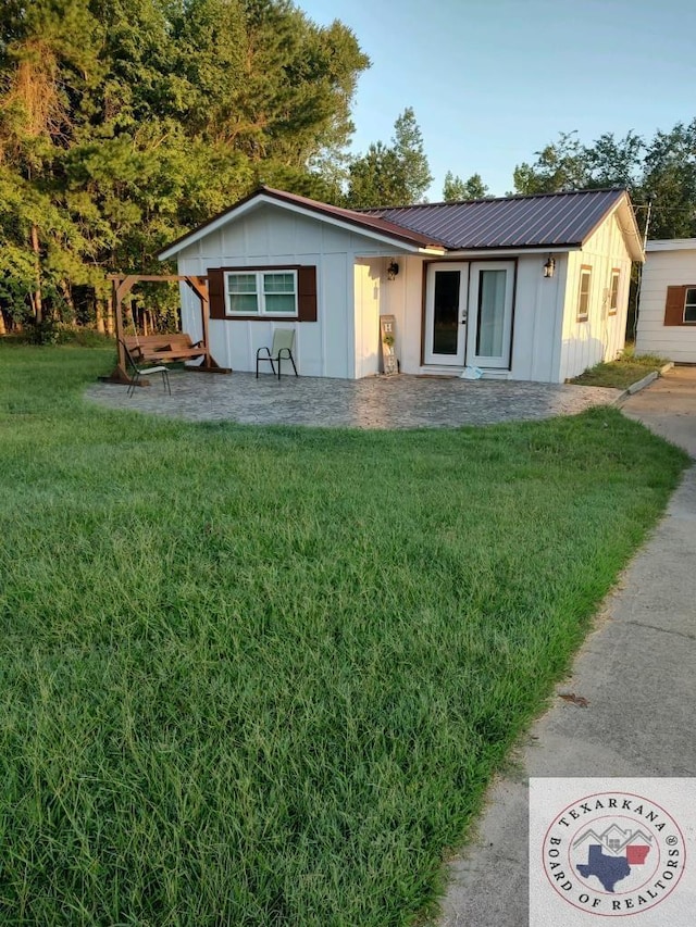 ranch-style house featuring a front yard and a patio area