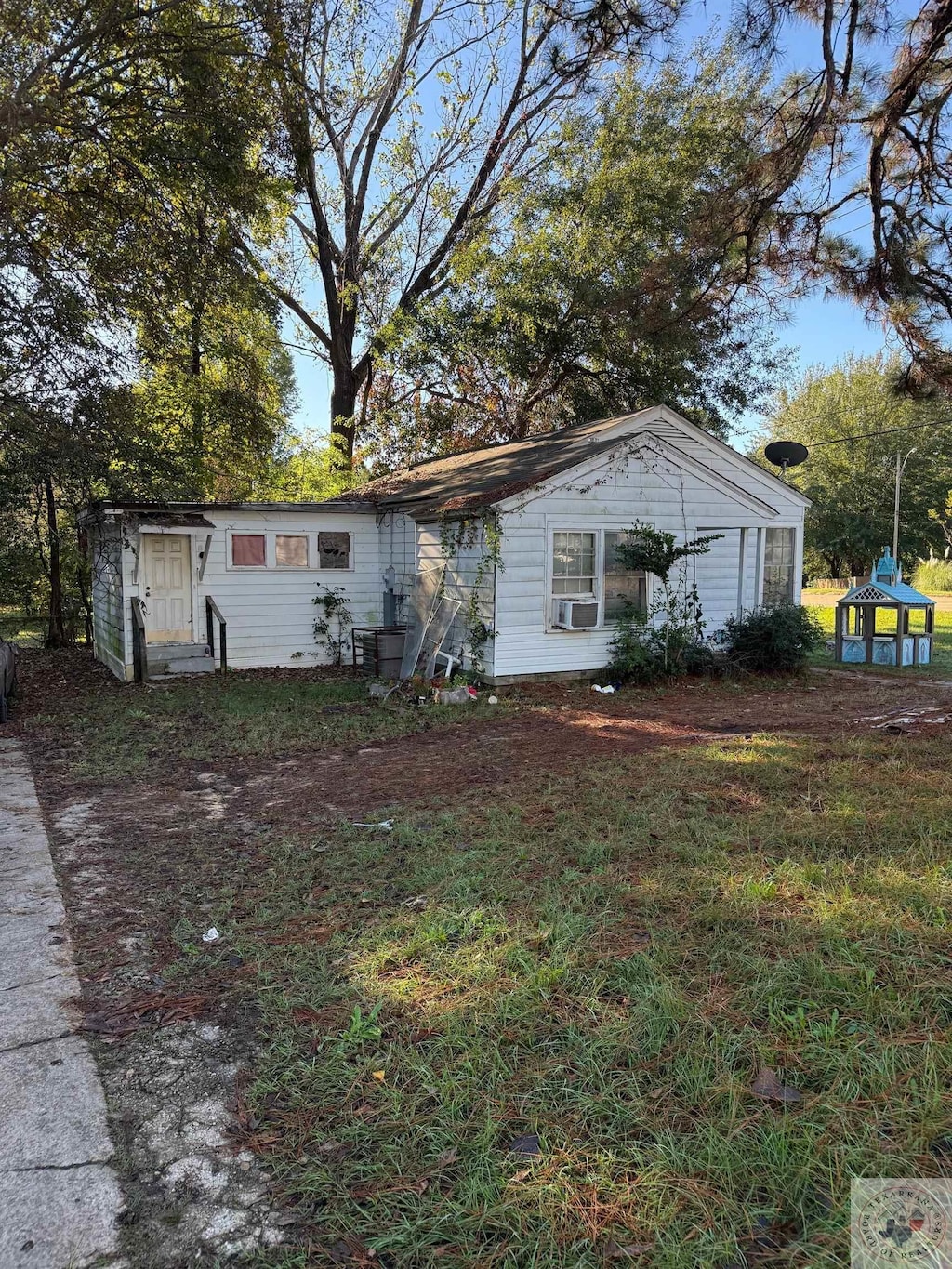 view of front of home featuring cooling unit and a front yard