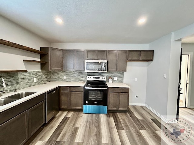 kitchen with decorative backsplash, sink, hardwood / wood-style flooring, and stainless steel appliances