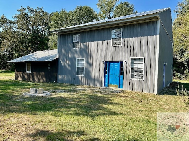 rear view of property with a yard