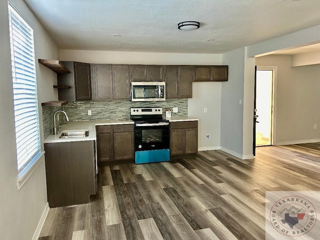 kitchen with sink, backsplash, a wealth of natural light, and range with electric cooktop