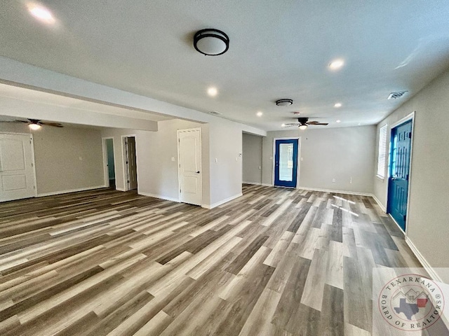 unfurnished living room featuring hardwood / wood-style flooring and ceiling fan